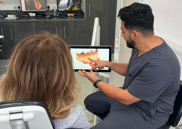 A smile design expert showing a patient her treatment plan