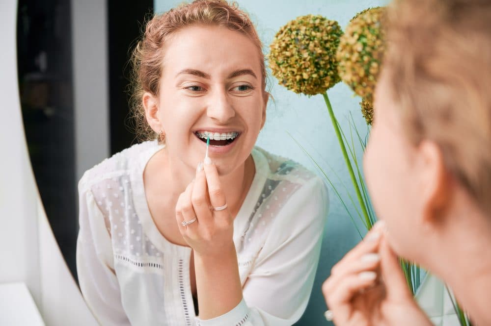 Woman cleaning teeth with interdental brush