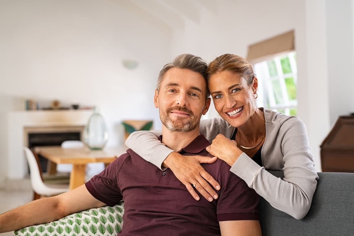 man and woman with dental implants smiling
